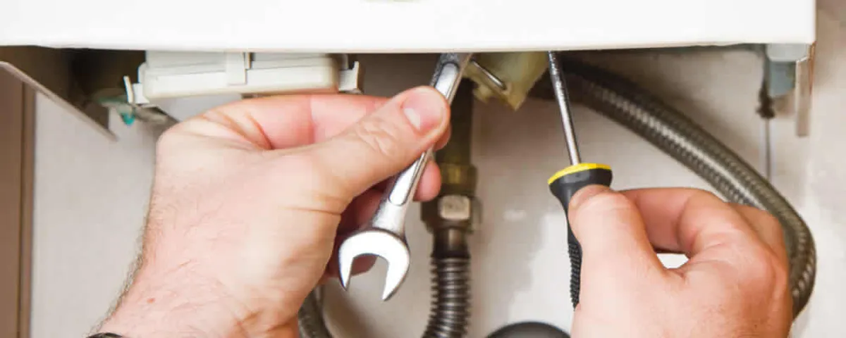 Boiler repair technician tightening pipe fittings and connections in Savannah, GA