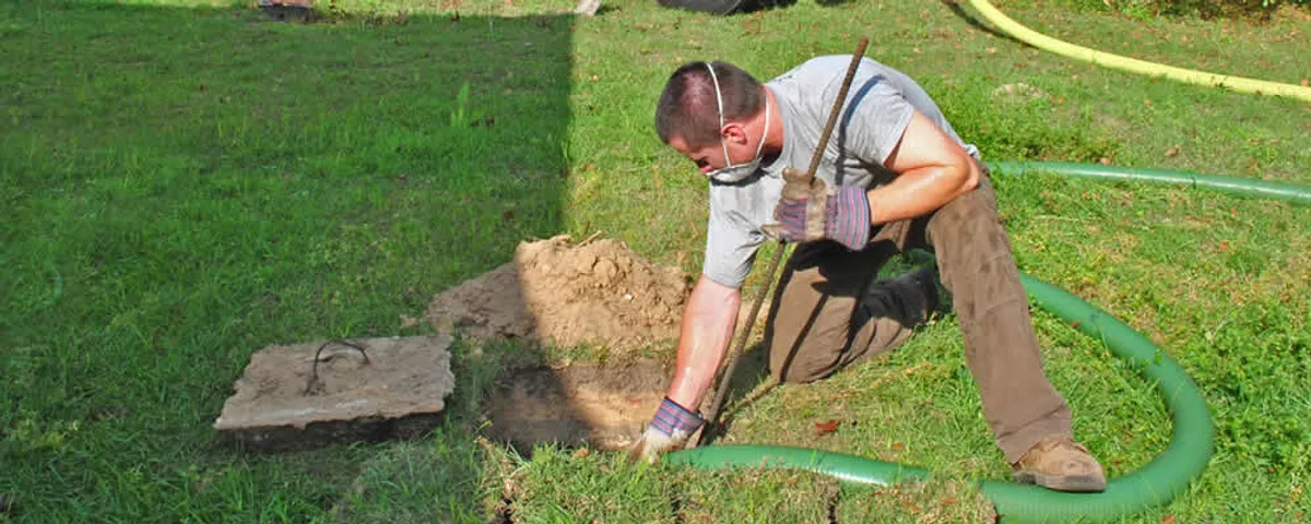 Septic pumping technician servicing a residential septic tank in Savannah, GA