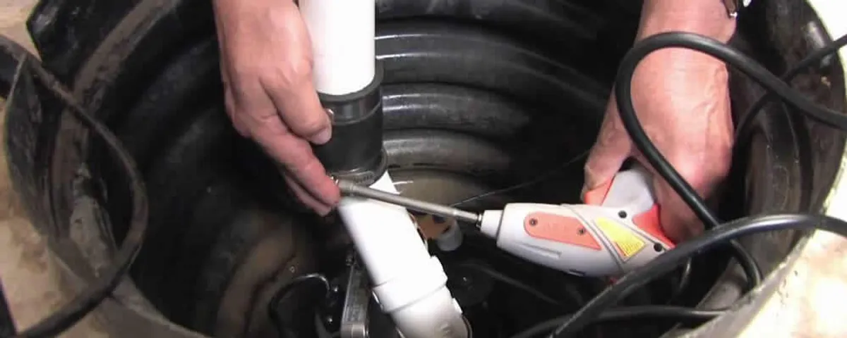 Sump pump installation technician connecting PVC discharge piping in Savannah, GA
